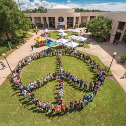 Students on East Campus assemble into a giant human peace sign.
