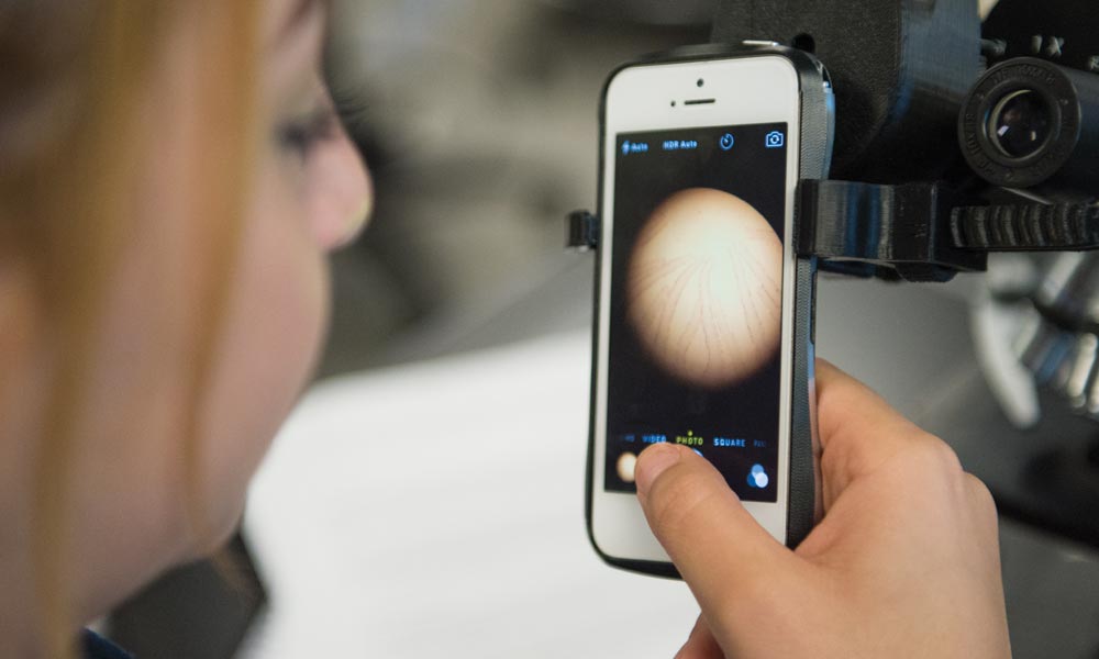 Biology students test a 3-D printed smartphone-to-microscope attachment created by Valencia student Josue Gimbernard.